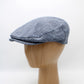 A blue and white textured flat cap displayed on a light wood mannequin head against a plain white background.
