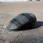 A black textured flat cap with a green plaid pattern, resting on a concrete surface outdoors.