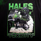 Close-up of a black graphic t-shirt featuring a green and white illustration of a hooded figure driving a van with smoke, with the text 'HALES' at the top and 'TOXICITY' at the bottom.