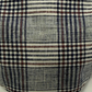 Close-up of plaid fabric with black, white, and brown colors.