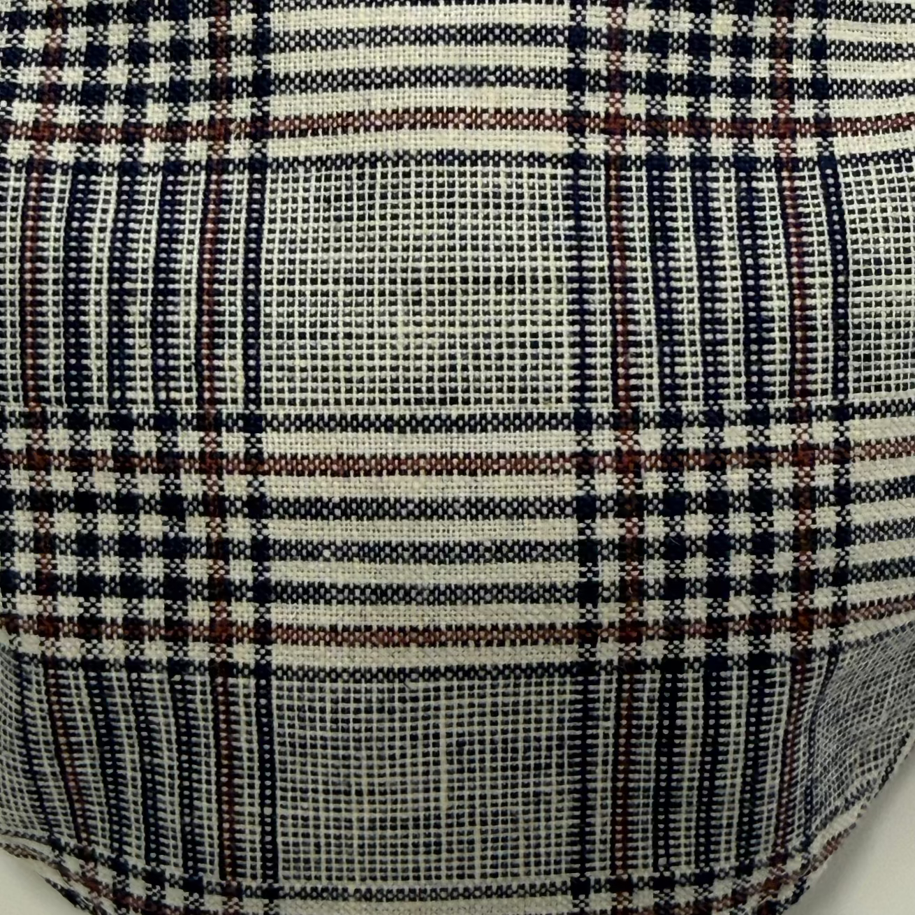 Close-up of plaid fabric with black, white, and brown colors.