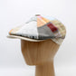 Patchwork cap on a wooden mannequin head against a white background