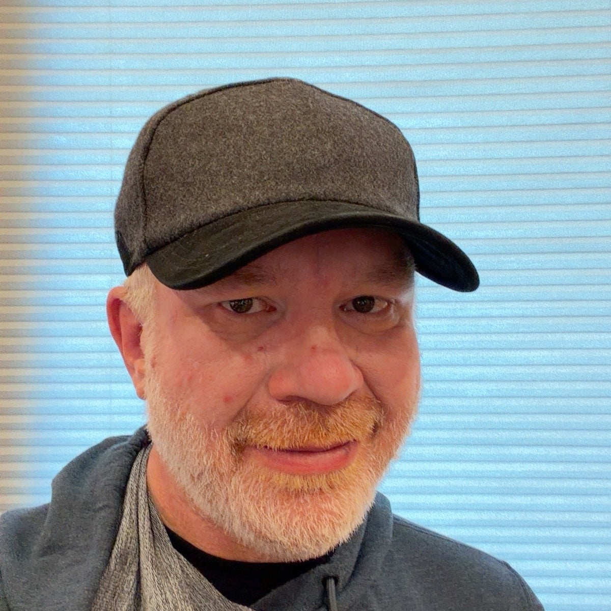 Gray Jade baseball cap worn with ear flaps tucked away