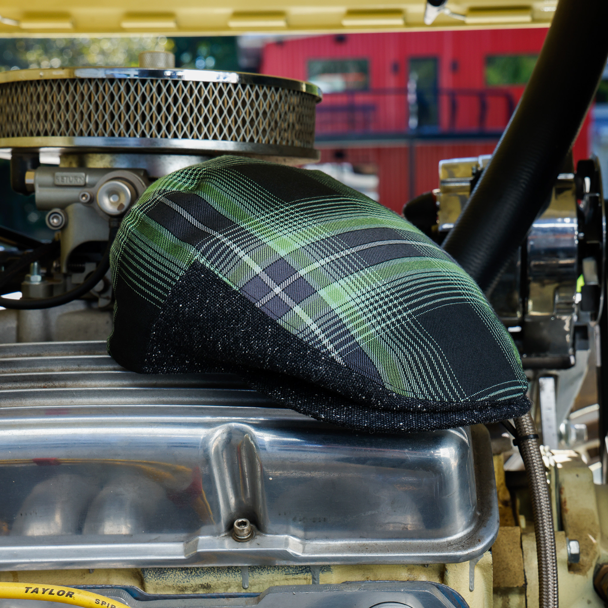 Wretch flannel flat cap, angled view showing green plaid crown and charcoal sides
