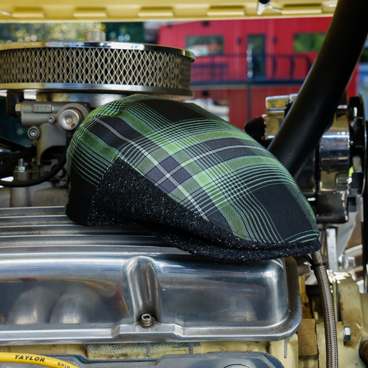 Wretch flannel flat cap, angled view showing green plaid crown and charcoal sides