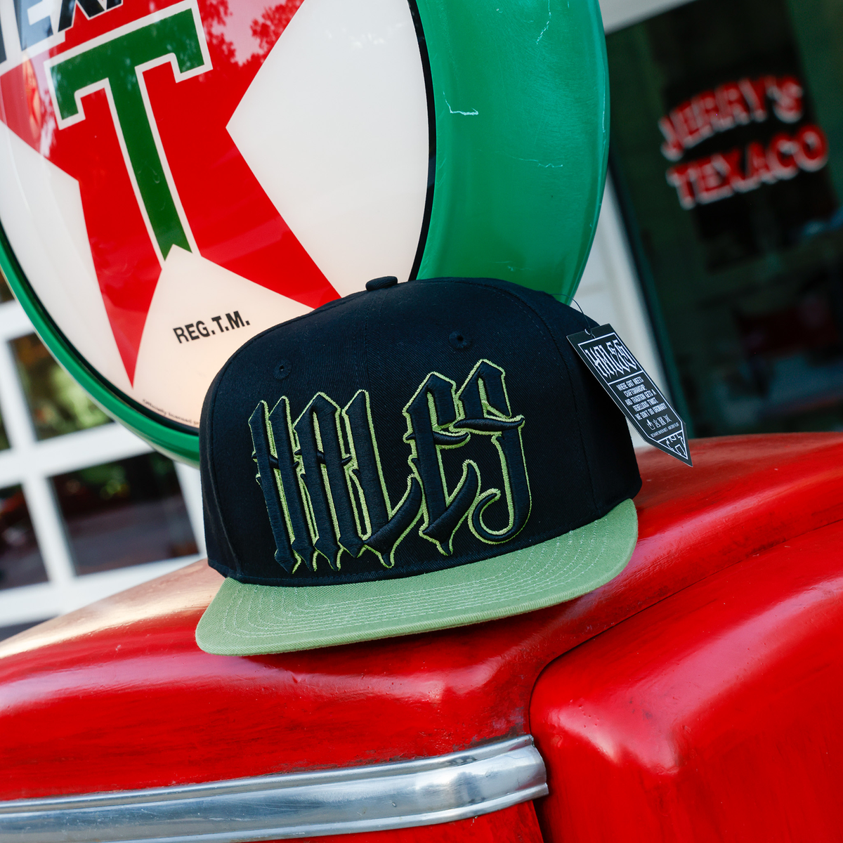 Wretch black snapback with green bill and outlined Hales embroidery